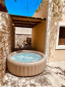a large circular tub sitting outside of a building at Bekos traditional house in Archangelos
