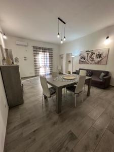 a living room with a table and chairs and a couch at Casa Inyco in Menfi