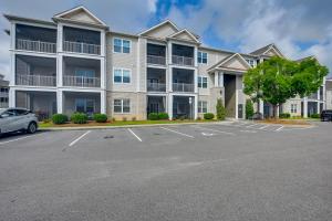 a large apartment building with a parking lot at Golf + Poolside Days! Condo 9 Mi to Sunset Beach in Calabash