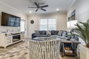 a living room with a couch and a tv at Golf + Poolside Days! Condo 9 Mi to Sunset Beach in Calabash