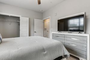 a bedroom with a bed and a flat screen tv at Golf + Poolside Days! Condo 9 Mi to Sunset Beach in Calabash +16 photos