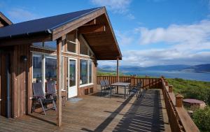 a house with a deck with a table and chairs at Brekka in Akranes