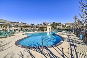a swimming pool at a resort with chairs and trees at Golf + Poolside Days! Condo 9 Mi to Sunset Beach in Calabash