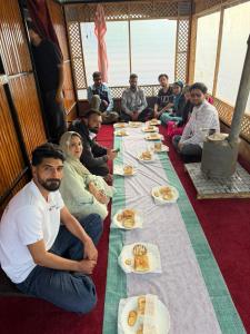 a group of people sitting around a long table with food at starry nights stay in Batakūt