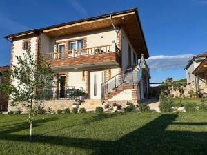 a large house with a deck on top of a yard at Mosaic Guesthouse in Lin