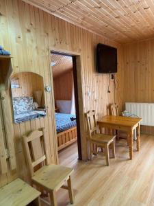 a room with a table and chairs and a television at Cube in Kvasy