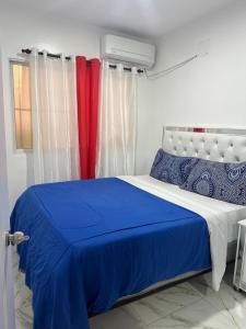 a bedroom with a blue and white bed with curtains at SahiR 2 in Cantabria