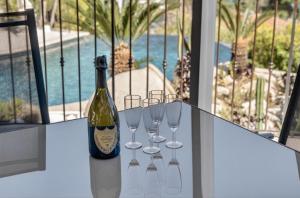 a bottle of wine and four wine glasses on a table at Villa Panorama in Éze