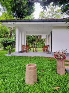 a patio of a house with benches in the grass at Claasz Prime Lagoon in Katunayaka