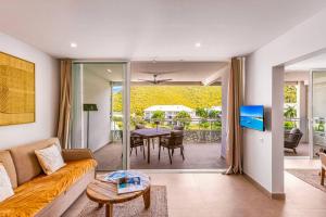 a living room with a couch and a table at Suite prestige Serenity Bay devant la plage in Anse Marcel 