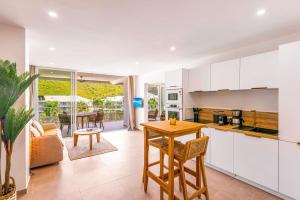 a kitchen and living room with a table and chairs at Suite prestige Serenity Bay devant la plage in Anse Marcel 