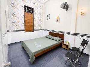 a bedroom with a bed and a chair in it at Phòng nghỉ 24h in Trung Nghĩa