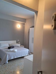 a bedroom with a white bed and a white refrigerator at B&B Giù di sotto in Gavi +1 photo