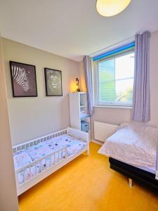 a small bedroom with a bed and a window at Gezinsvriendelijk natuurhuis De Kraanvogel in Appelscha