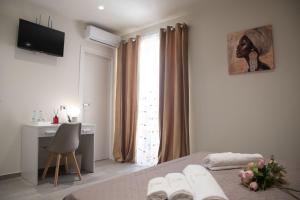 a bedroom with a bed and a desk and a window at Il Vicolo al Centro in Raffadali