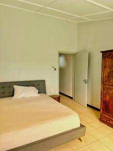 a bedroom with a bed and a wooden cabinet at 11 Residence Thalassa in Belle Mare
