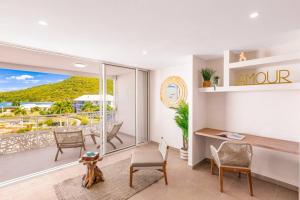a living room with a desk and a view of the ocean at Suite prestige Karibean Paradise devant la plage in Anse Marcel 