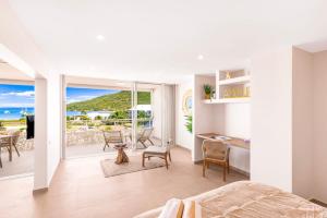 a bedroom with a bed and a desk and a balcony at Suite prestige Karibean Paradise devant la plage in Anse Marcel  +9 photos