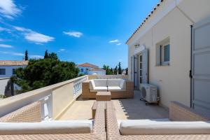 a balcony with a couch and a tv on a building at Mimoza in Spetses