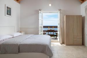 a bedroom with a bed and a view of the ocean at Villa Insula by Belmont Realty in Vela Luka