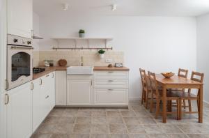a kitchen with white cabinets and a wooden table at Villa Insula by Belmont Realty in Vela Luka