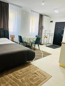 a bedroom with a bed and a table and chairs at Nicotel in Turda