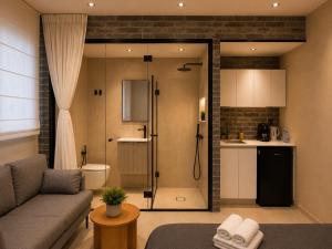 a living room with a shower and a couch at Dizengoff Square Garden - by BAR COLLECTION in Tel Aviv +3 photos