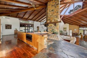 an open kitchen with wooden cabinets and a stone wall at The Hills Opera House in Bickley