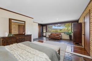 a bedroom with a bed and a couch and a window at The Hills Opera House in Bickley