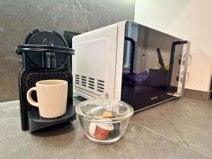 a microwave sitting on a counter with a cup and a mug at YourHouse As Escadas in Allariz