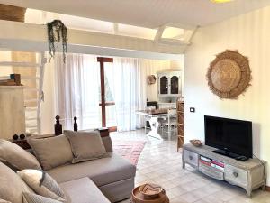 a living room with a couch and a flat screen tv at Grace House in Marina di Sorso