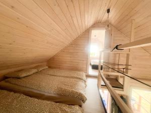 a small room with a bed and a staircase at Serce Puszczy in Drawsko