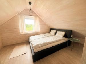 a bed in a small room with a window at Serce Puszczy in Drawsko