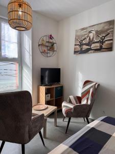 a bedroom with a bed and two chairs and a tv at 105 - Voiron centre - DeTassigny in Voiron