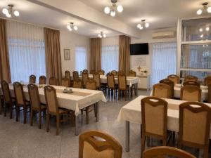 a conference room with tables and chairs and a television at Sobe Ivan-Popić in Međugorje