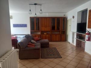 a living room with a couch and a television at Da Elena e Michele in Coazze