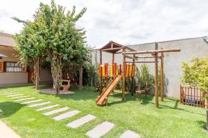 a playground with a slide in a yard at Pousada das Bandeiras in Olímpia