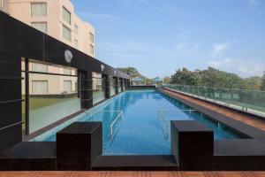 ein großes Schwimmbecken an der Seite eines Gebäudes in der Unterkunft Indore Marriott Hotel in Indore