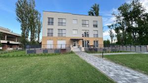 a large building with a grassy yard in front of it at Gyöngybagoly Apartman in Balatonberény