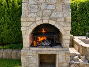 a stone oven with a fire inside of it at Complex Sea & Sky next to the Beach ! in Kranevo +71 photos