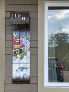 a window with a sign on the side of a house at Chalet Potvin Bouchard in LʼAnse-Saint-Jean