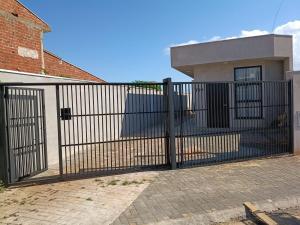 a black gate in front of a house at New House, Long Stay in Maringá