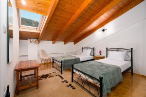 two beds in a room with a wooden ceiling at Epi tis Stigos in Kalavrita