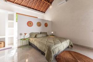 a bedroom with a bed and two tables with lamps at NEW Sawah Escape - Tropical 2BR with Pool and Views in Tabanan