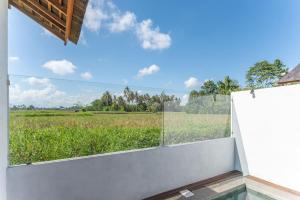 a view of a field from the balcony of a house at NEW Sawah Escape - Tropical 2BR with Pool and Views in Tabanan