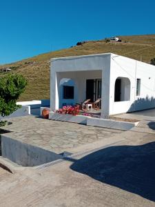 a white house with a hill in the background at Aethalios katoikia in Korissia