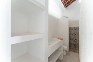 a white bathroom with a toilet and a sink at NEW Sawah Escape - Tropical 2BR with Pool and Views in Tabanan +38 photos