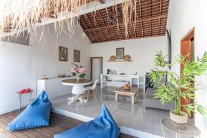 a living room with blue pillows and a table at NEW Sawah Escape - Tropical 2BR with Pool and Views in Tabanan