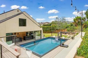 a home with a swimming pool and a house at Modern Encinitas Retreat in Encinitas