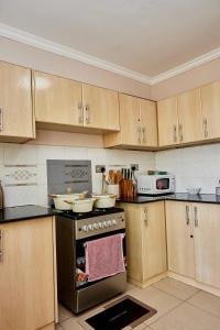 a kitchen with wooden cabinets and a stove top oven at Lakeview 3Bedroom Condo with heated pool in Nakuru Town in Nakuru